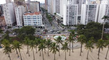 vista aérea do bairro a partir da faixa de areia, de frente para a praça das bandeiras e avenida ana costa. Em primeiro plano se vê as copas verdes das palmeiras e as construções em seguida. #paratodosverem