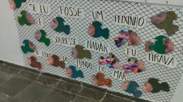 painel ilustrado com peixinho e a os seguintes dizeres: se eu fosse um peixinho e soubesse nadar eu tirava o lixo do fundo do mar. #paratodosverem 