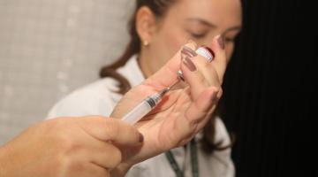 mãos preparam seringa para vacinação #paratodosverem