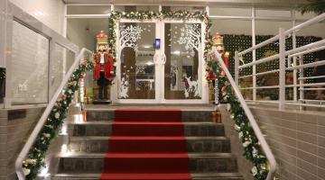entrada de edifício decorada com festões, soldadinhos e muitas luzes. #paratodosverem