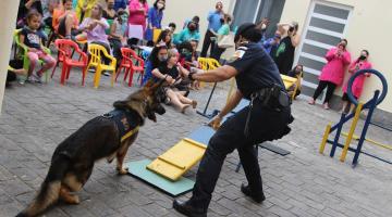 Guarda orienta cachorro em apresentação com crianças assistindo #paratodosverem