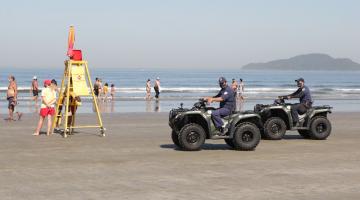 dois quadriciciclos são pilotados por guardas muncipais na faixa de areia da praia próximo à água. #paratodosverem