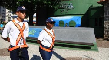 dois jovens usando uniforme, com bone e colete reflexivo. #paratodosverem 