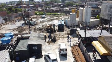 vista aérea de canteiro de obras, com perfuratrizes ao fundo à esquerda e tanques à direita. #paratodosverem