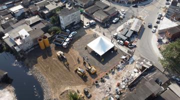 vista aérea de canteiro de obras, com caminhões e retroescavadeiras. #paratodosverem