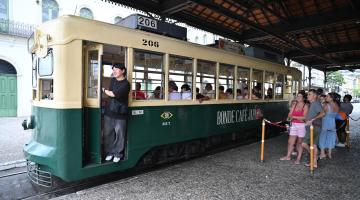Pessoas aguardam para o passeio no bonde. #Paratodosverem.