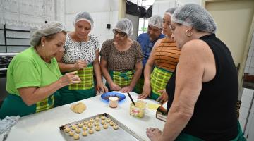 mulheres assistem a produção de biscoitos artesanais. #paratodosverem