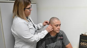 Paciente recebe aparelho auditivo na unidade de saúde. #Paratodosverem