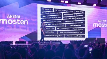 pessoa em pé com telão ao fundo #paratodosverem