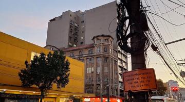 poste na rua com emaranhado de fios. #paratodosverem