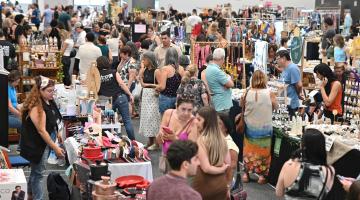 salão com expositores e grande movimento de público. #paratodosverem