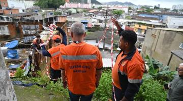 homens da defesa civil olham trecho de barranco em morro. #paratodosverem