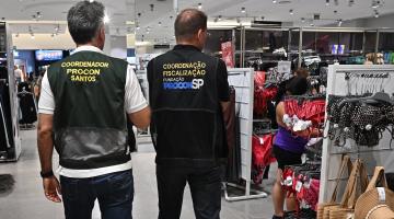 fiscais com coletes de identificação dentro de loja. #paratodosverem 