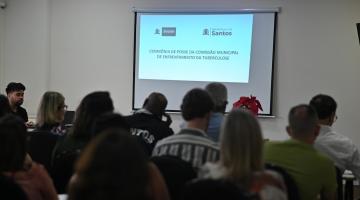 pessoas reunidas em sala vendo telão #paratodosverem 