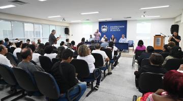 pessoas sentadas em um auditório #paratodosverem