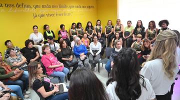 mulheres reunidas em salão assistem palestra. #paratodosverem