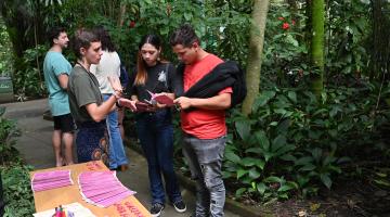 pessoas conversam no orquidário. #paratodosverem
