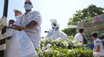 imagem de iemanja cercada de flores e pessoas em cima do carro #paratodosverem