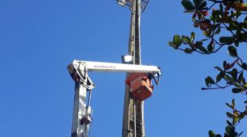 Trabalho em torre de iluminação na praia #paratodosverem