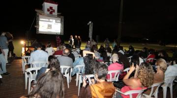 pessoas assistem à exibição no terraço do cinema #paratodosverem