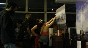 pessoas apontam para foto em exposição #paratodosverem 