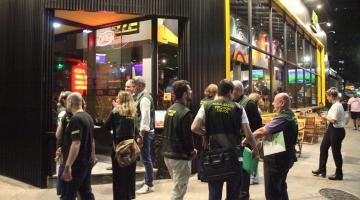fiscais uniformizados do procon em frente a um bar. #paratodosverem
