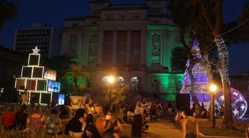 pessoas na praça e arvores iluminadas #paratodosverem