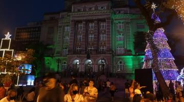 pessoas andando  no centro em meio a iluminação especial #paratodosverem