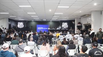pessoas sentadas assistindo apresentação em palco. #paratodosverem