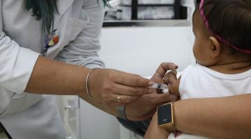 mãos de mulhere vacinam bebê de colo #paratodosverem