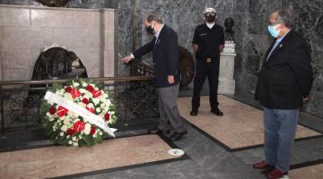 #pracegover No Panteão dos Andradas, dois homens observam flores junto ao túmulo de Bonifácio