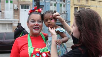 artista faz pintura em rosto de criança