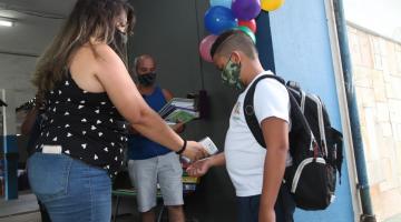 mulher mede temperatura de aluno na porta de escola #paratodosverem 