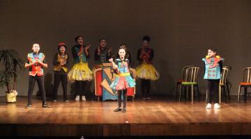 estudantes fazem apresentação teatral em palco. #paratodosverem