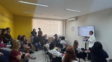 mulheres sentadas em auditório assistem palestra. #paratodosverem