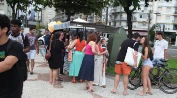 pessoas olhando produtos em barraca #paratodosverem