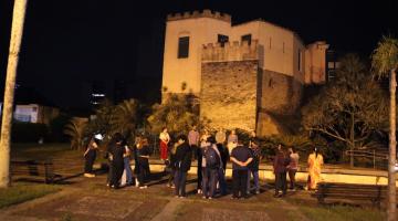 grupo de estudantes em torno de monumento. #paratodosverem 