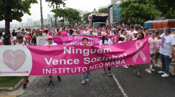 caminhada com faixas e pessoas vestidas de cor-de-rosa. #paratodosverem 