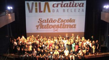 turma de formando se junta em palco para foto. ao fundo um grande banner onde se lê Vila Criativa da Beleza salão escola Autoestima