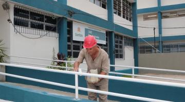 homem pinta corrimão de rampa de acesso. #paratodosverem