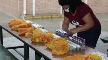 mulher separa alimentos para montar kit #paratodosverem 