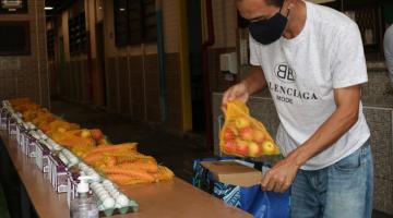 homem coloca alimentos em sacola #paratodosverem 