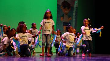 crianças se apresentando em palco #paratodosverem 