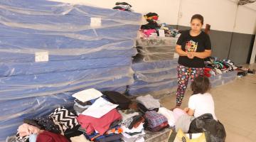 pessoas pegam doações em abrigo #paratodosverem