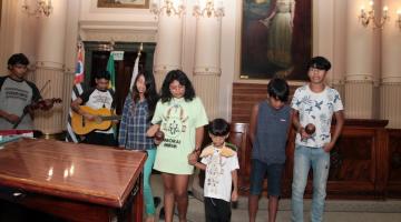 jovens e crianças fazem apresentação de dança e música na sala princesa isabel. São sete pessoas no total. #paratodosverem