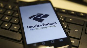 smartphone aberto sobre teclado de computador. #paratodosverem