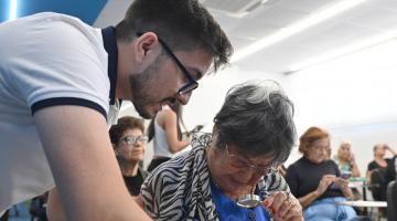 rapaz ajuda idosa em aula #paratodosverem