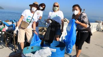 Mulheres na praia com sacos de lixo #paratodosverem