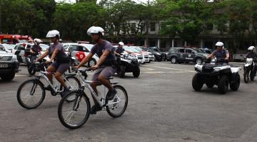 Policiais em bicicletas, quadriciclos e viaturas ao fundo #paratodosverem