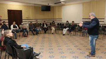 pessoas assistem palestra em salão. #paratodosverem 